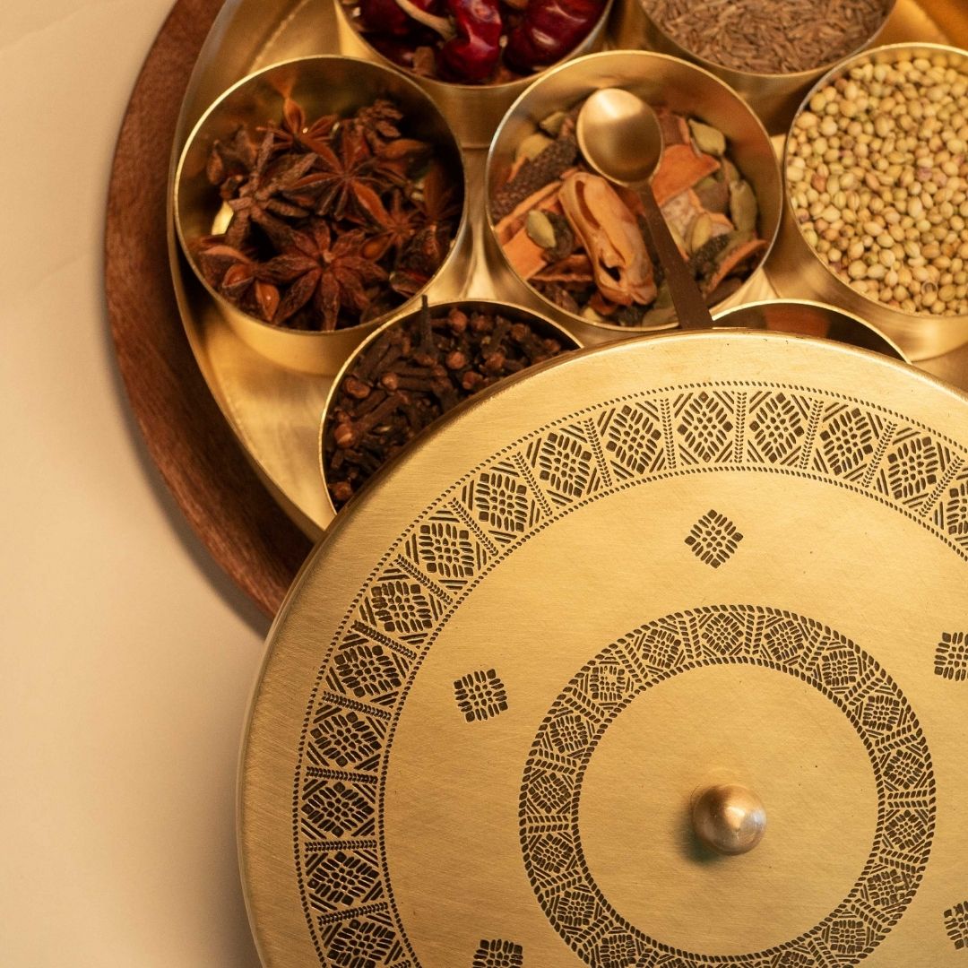 Handcrafted pure brass kitchen masala box with Kanjeevaram-inspired etching, adding timeless Indian elegance.