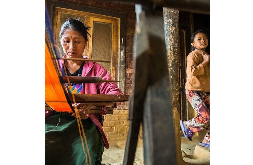 A woman weaving on loin loom
