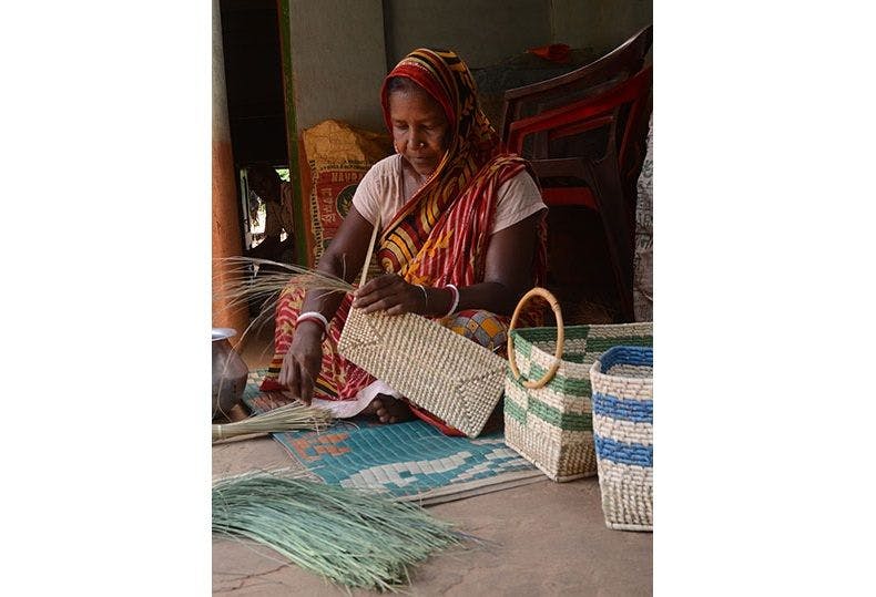 A woman crafting products from Sabai Grass 