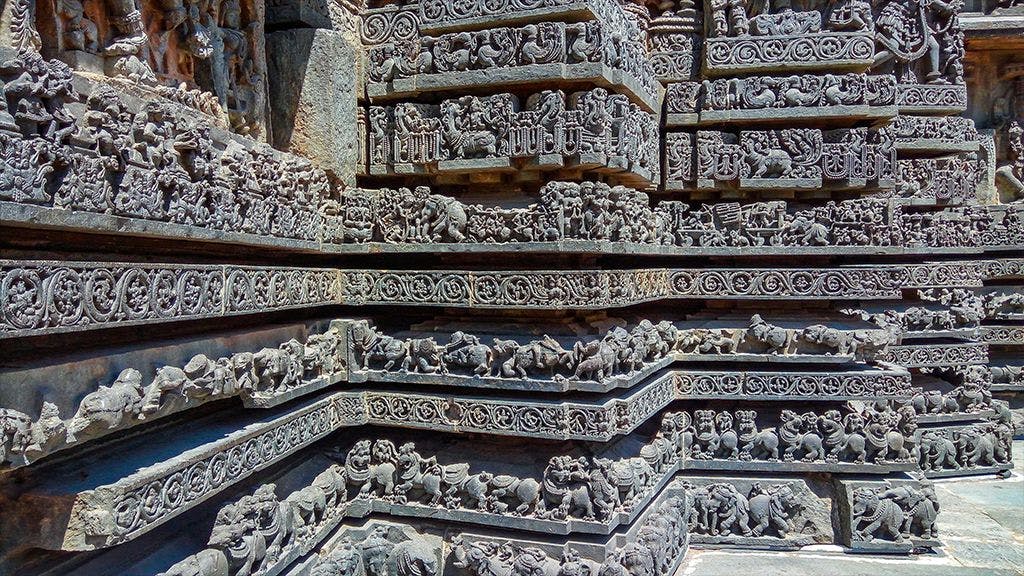 A close view of the detailing on the exterior of the temple which showcases warriors, mythical characters and animals such as elephants, crocodiles and swans.