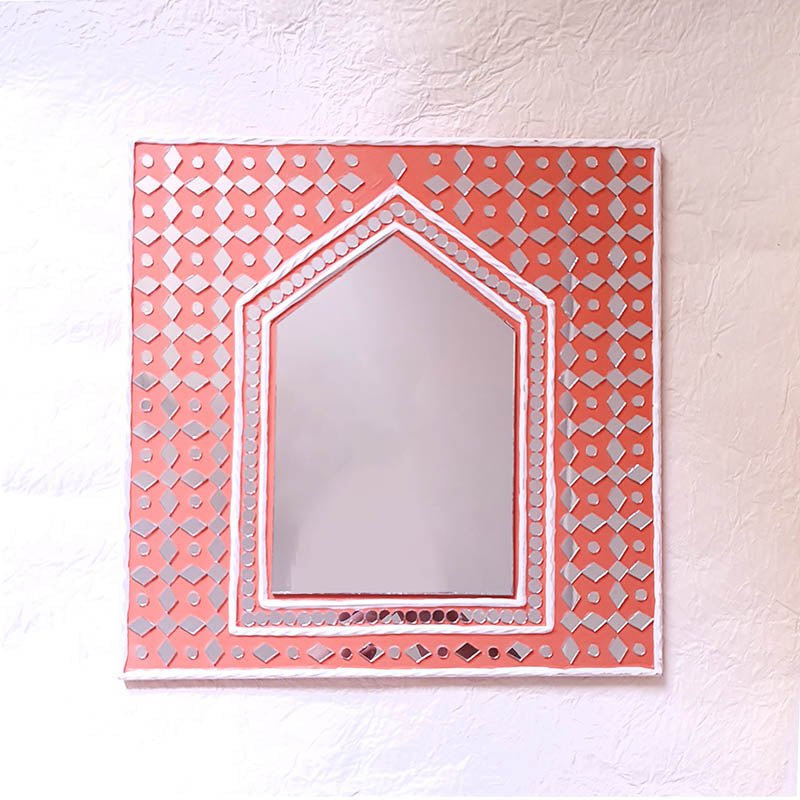 Bright brick red handcrafted mud art mirror, adding warmth and character