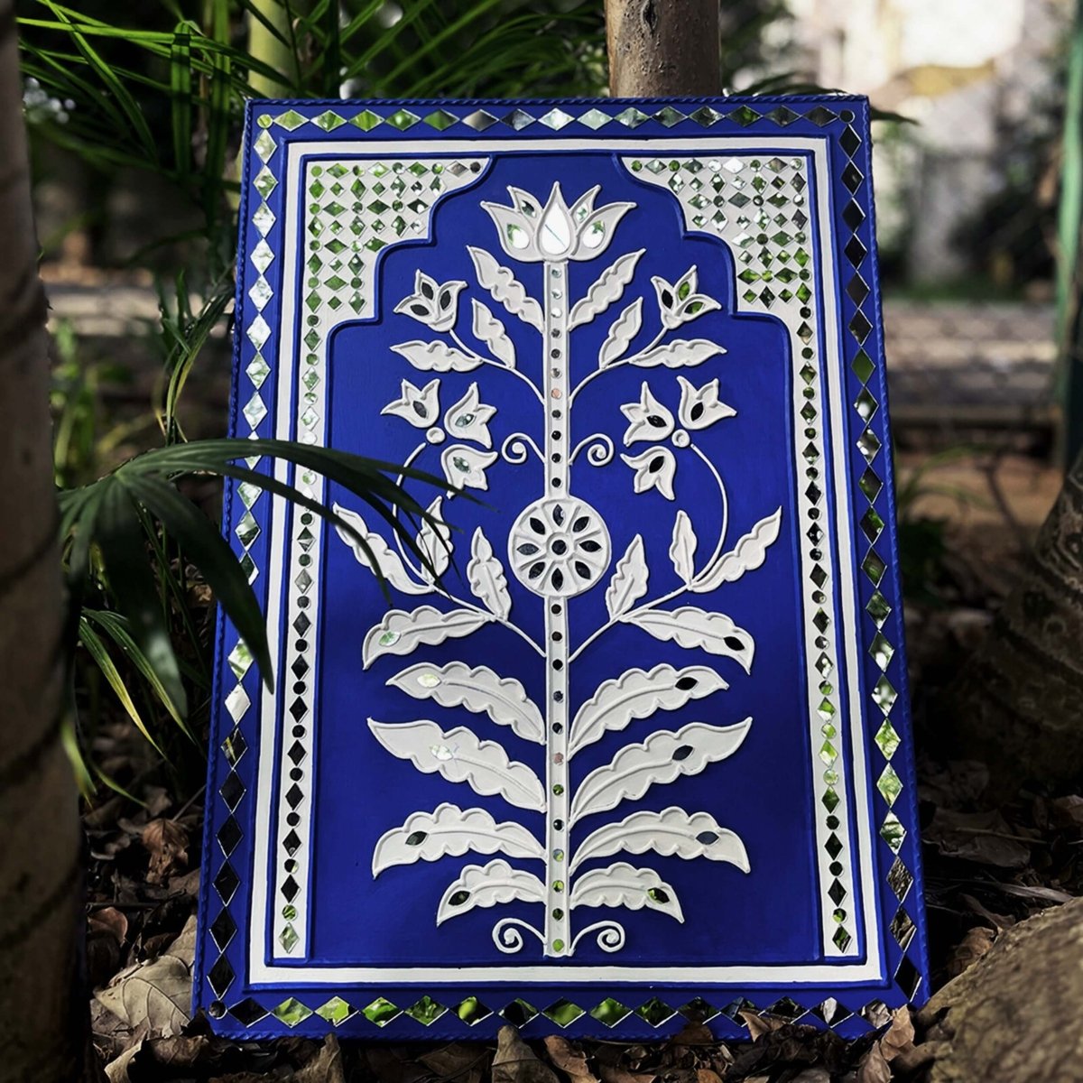 Handmade blue sparkle mud art wall hanging crafted with mud and mirrors from Kutch.